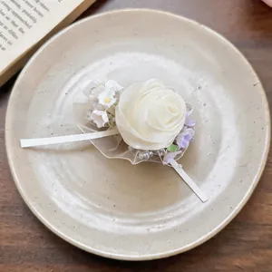 Close-up detail of an elegant cream chiffon rose hair clip with pearls and lace ribbon