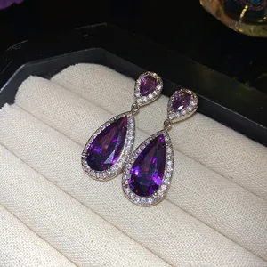 Dettaglio elegante di orecchini pendenti in argento con zirconi viola a goccia d'acqua