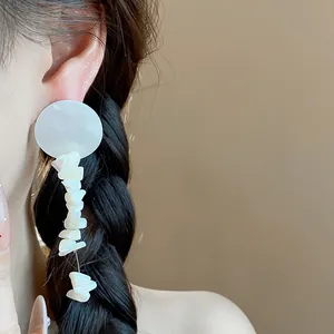 Elegantes pendientes de botón redondos blancos con fragmentos de concha irregulares colgantes