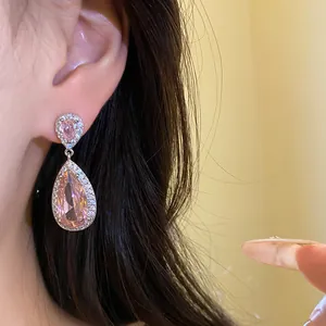 Dettaglio ravvicinato di squisiti orecchini a goccia rosa con design a alone scintillante