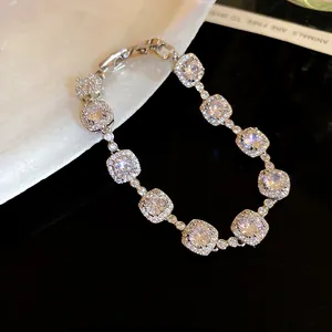 Détail macro d'un élégant bracelet plaqué or 18k avec oxydes de zirconium carrés.