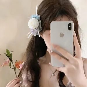 Elegant fabric chiffon flower hair clip worn by model in soft lighting