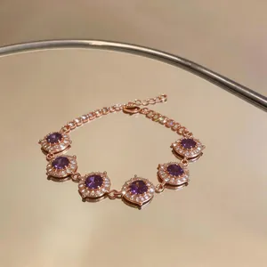 Vista dettagliata di un bracciale in oro rosa con zirconi viola rotondi e cristalli
