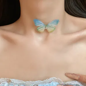 Close-up of a gradient blue and green butterfly choker necklace on a model.