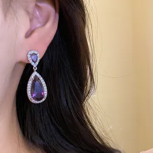 Primo piano di eleganti orecchini a goccia con zircone viola in montatura d'argento
