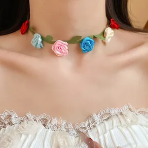 Close-up detail of a colorful fabric rose floral choker necklace worn by a model.