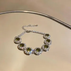 Primo piano di un bracciale in zircone verde oliva con dettagli floreali lucidi