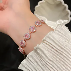 Elegante bracciale in oro rosa con zirconi rosa rotondi al polso di una donna