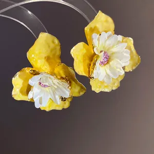 Pendientes de flores de esmalte amarillo con pétalos de tela blanca y purpurina rosa