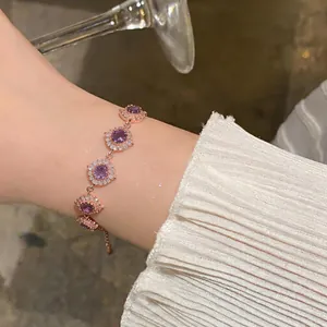 Vista dettagliata di un elegante bracciale in oro rosa con zircone viola e pietre bianche.