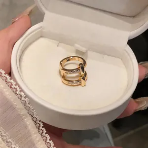 Elegant gold double-band ring with stones detail in a premium white jewelry box