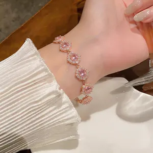 Dettaglio di un elegante bracciale in oro rosa con zirconi rosa circolari e piccoli aloni.