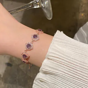 Dettaglio di bracciale in oro rosa con zircone viola e cristalli bianchi scintillanti