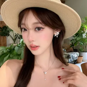 Primo piano di eleganti orecchini a fiore su una bella modella con cappello di paglia