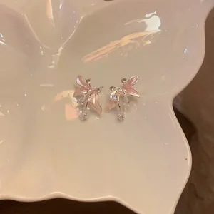 Eleganti orecchini a lobo a fiore rosa con zirconi su vassoio a farfalla bianco