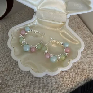 Detailed view of French style hoop earrings with pastel pearls and cubic zirconia stones