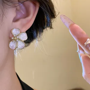 Detailed view of elegant flower stud earrings featuring pink enamel petals and crystals