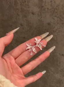 Primo piano di orecchini a fiore eleganti con zirconi e petali in smalto bianco