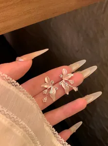 Vista dettagliata di eleganti orecchini a fiore in zircone con petali rosa nella mano