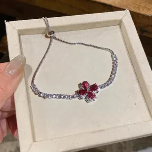 Elegant silver bracelet with red zircon flower pendant presented in a gift box