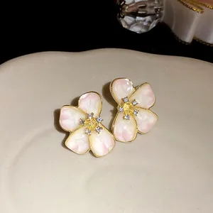 Close-up of elegant pink enamel flower stud earrings with sparkling crystal center