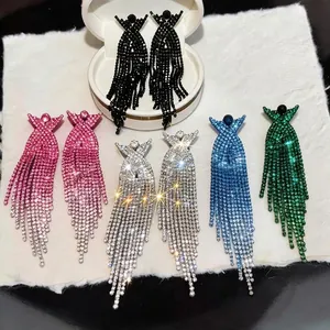 Eleganti orecchini pendenti con nappe di strass a croce X in vari colori alla moda.