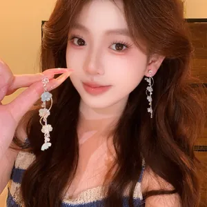 Close-up of long floral tassel earrings with zircon details on an Asian model