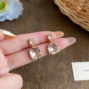 Close-up detail view of elegant 18k gold plated zircon earrings with clear stones.