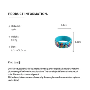 Macro view of blue resin bangle with colorful tropical fish print and dimensions