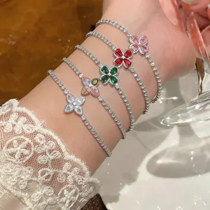 Close-up view of five colorful zircon flower bracelets on a wrist with lace detail.
