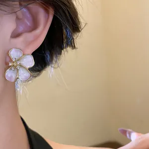 Close-up of elegant flower stud earrings with rhinestones on a model's ear