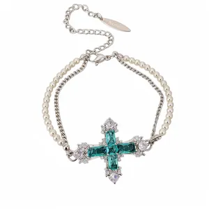 Elegant double-layered silver necklace featuring a stunning emerald green zircon cross pendant.