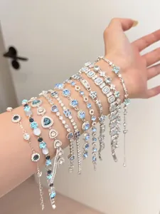 Gros plan de plusieurs bracelets en zircone bleue et blanche de style français au poignet
