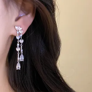Dettaglio di eleganti orecchini a nappa lunga con scintillanti cristalli a cuore