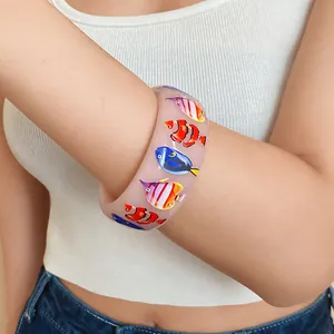 Close-up of tropical fish print resin bangle with colorful nemo and dory designs