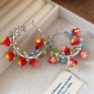 Handmade silver needle hoop earrings featuring colorful glass beads and red flowers