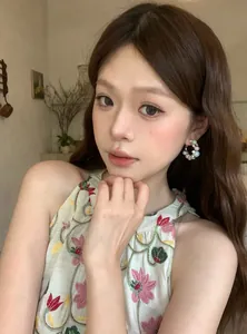 Close-up of French style hoop earrings with pearls and colorful beads on model