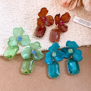 Detailed view of colorful acrylic flower earrings with faceted crystal drops.