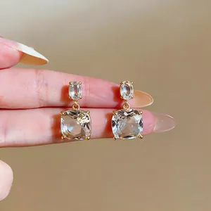 Macro detail of 18k gold-plated stud earrings with elegant clear zircon crystals