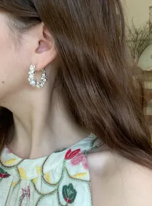 Elegant French style pearl and zircon hoop earring displayed on model's ear detail view