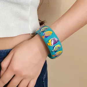 Detailed view of wide turquoise resin bangle featuring colorful tropical fish prints.