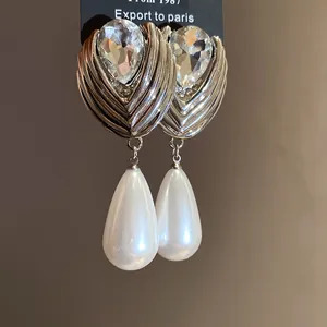 Dettaglio ravvicinato di eleganti orecchini di lusso con perle a goccia e cristalli