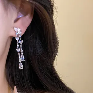 Dettaglio macro di eleganti orecchini a nappa in argento con pietre sfaccettate