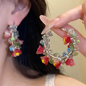 Colorful Mori-style glass beaded hoop earrings featuring delicate handmade flower charms