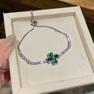 Macro view of a sparkling green zircon clover bracelet with an adjustable slider clasp