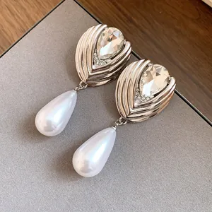 Primo piano di eleganti orecchini a goccia con strass e perle in finitura argento