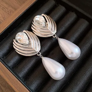Dettaglio ravvicinato di eleganti orecchini a goccia in argento con perle e cristalli