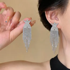 Eleganti orecchini pendenti in strass argentati con dettaglio a croce X e lunghe frange
