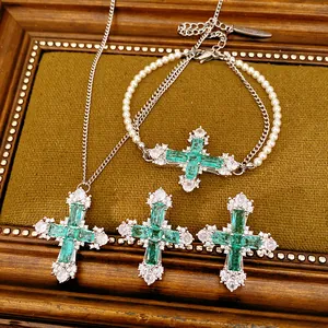 Detailed view of luxury emerald green cross zircon necklace, bracelet and earrings set