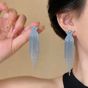 Primo piano di eleganti orecchini a nappa con strass a croce a X color argento